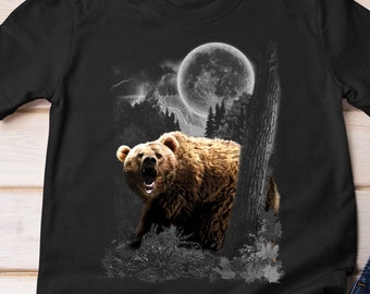 Può includere: Maglietta nera con una grafica di un orso bruno che ruggisce davanti a una luna piena e alberi.