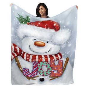 May include: A white snowman with a red and white striped scarf and a red Santa hat with white fur trim. The snowman is holding a sign that says "JOY" in colorful letters.