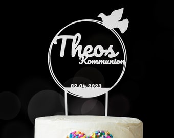Könnte beinhalten: Weißer Tortendekor mit einem Kreis und dem Text "Theos Kommunion 02.04.2023" und einer Taube oben drauf.