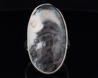 Può includere: Un anello d'argento con una grande pietra di agata ovale di colore grigio e bianco.