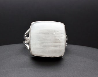 May include: A silver ring with a white selenite gemstone. The ring has a square-shaped setting and a smooth, polished finish.