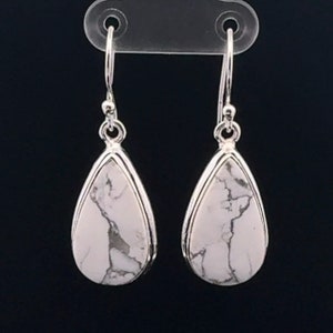 May include: A pair of silver teardrop earrings with white howlite stones.