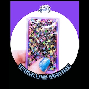 May include: A rectangular sensory squish toy filled with colorful butterfly and star-shaped confetti. The toy is held by a hand with a blue painted fingernail. The text "Butterflies & Stars Sensory Squish" is visible.