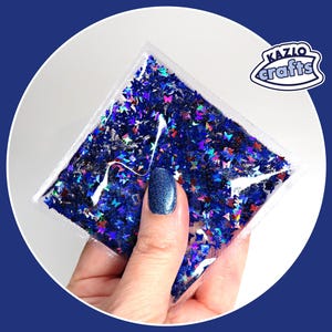 Squish Carré II Oh My, papillons et étoiles holographiques | Gestion du stress | Activité sensorielle spongieuse scintillante
