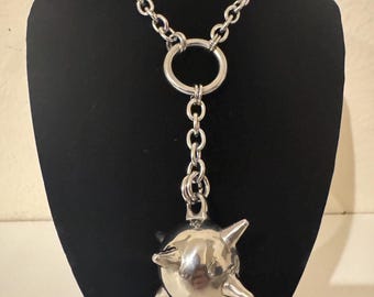 May include: A silver chain necklace with a large, spiked ball pendant. The chain is thick and has a large, round link at the top. The ball is about 2 inches in diameter and has 6 sharp spikes.