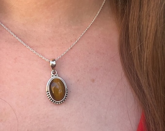 Collar con colgante ovalado de plata de ley con ojo de tigre.
