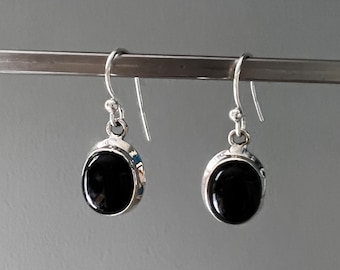 Pendientes de ónix negro: Clásicos pendientes colgantes ovalados de plata.