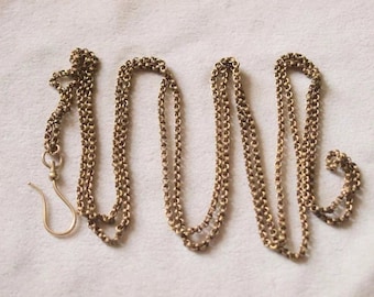 May include: A gold chain necklace with a hook clasp. The chain is made of multiple strands of small, linked circles.
