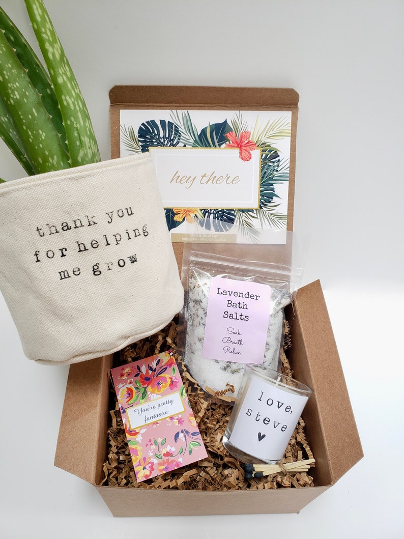 May include: A brown gift box filled with a small potted plant, a bag of lavender bath salts, a small candle, and a card that says "You're pretty fantastic". The box also includes a card with the text "thank you for helping me grow" and a card with the text "hey there".
