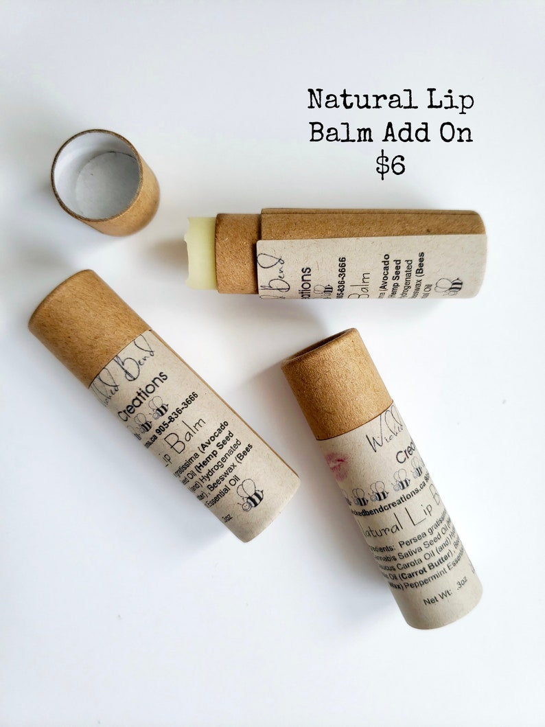 May include: Two brown cardboard tubes of natural lip balm with a white label and black text. The label reads "Bend Creations Lip Balm" and lists the ingredients. The text "Natural Lip Balm Add On $6" is printed in black on a white background.