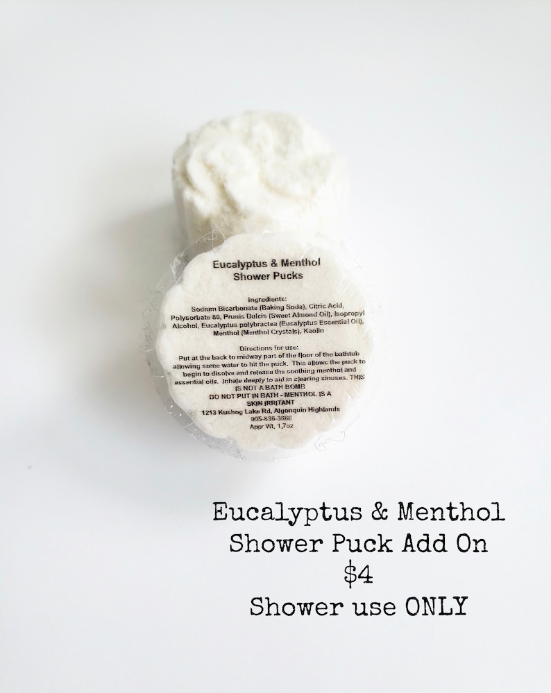 May include: Two white shower pucks with the text "Eucalyptus & Menthol Shower Pucks" and a list of ingredients and directions for use. The text "Eucalyptus & Menthol Shower Puck Add On $4 Shower use ONLY" is below the image of the pucks.