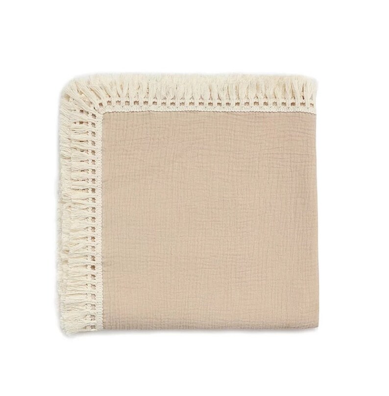 Op de afbeelding: Een zacht, roze babydekentje met een witte gehaakte rand en franjes.