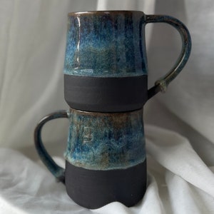 Handmade ceramic mugs made of stoneware clay with blue glaze