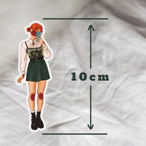 May include: A sticker of a woman with red hair wearing a green skirt and a white shirt with a camouflage pattern. She is holding a phone up to her face and smiling. The sticker is 10 cm tall.