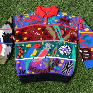 May include: A colorful knitted sweater with a multi-colored pattern of birds, flowers, and geometric shapes. The sweater has a red collar and a button closure.