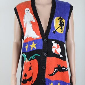 Pu&ograve; includere: Un gilet di maglina nero senza maniche con un tema di Halloween colorato. Il gilet presenta un fantasma, una strega, una zucca, bastoncini di zucchero e pipistrelli. Il gilet ha un collo a V e bottoni sul davanti.