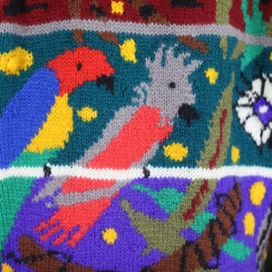 May include: A colorful knitted sweater with a multi-colored pattern of birds and flowers. The sweater is made of a soft, warm yarn and has a relaxed fit.