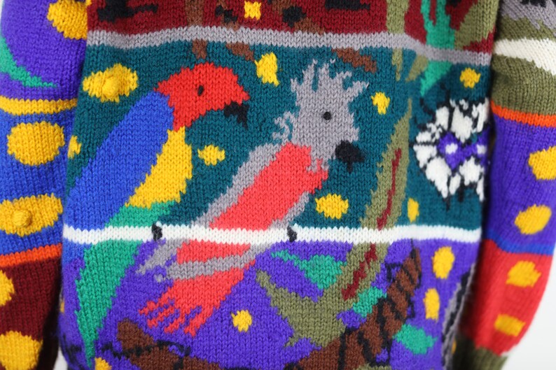May include: A colorful knitted sweater with a multi-colored pattern of birds and flowers. The sweater is made of a soft, warm yarn and has a relaxed fit.