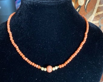 Turn of the neck in coral and gold