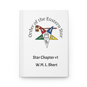 May include: A white journal featuring the Order of the Eastern Star emblem. The emblem is a five-pointed star with various symbols and the text "Order of the Eastern Star." Below the emblem is "Star Chapter #1" and "W.M.L. Short."