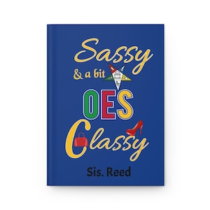 May include: A blue hardcover journal featuring the yellow text Sassy & a bit Classy, with a multi-colored Order of the Eastern Star emblem, a red handbag icon, a red high-heeled shoe icon, and the black text Sis. Reed printed on the front cover.