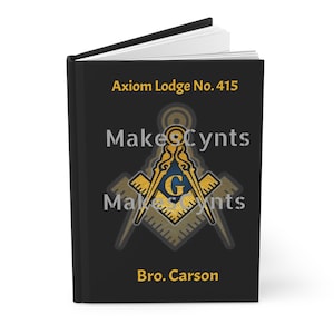 May include: Black book with the title "Axiom Lodge No. 415" and the text "Bro. Carson". A gold Masonic symbol with a "G" in the center is on the cover.