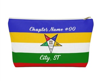 May include: A rectangular cosmetic bag with a blue top, yellow stripe, white stripe, green stripe, and red bottom. The bag features a gold zipper and a star emblem. Text on the bag reads "Chapter Name #00" and "City, ST".