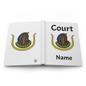 May include: A white notebook with the word "Court" and "Name" printed on the cover in black. The notebook features a colorful illustration of an Egyptian figure with a gold frame.