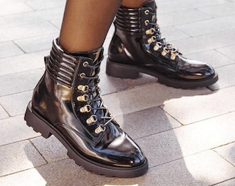Black vegan leather ankle boots, latex effect. Refined and elegant gold color details.