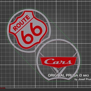 May include: Two 3D printed wall decorations, one with a red Route 66 sign and the other with a red Cars logo. Both are printed in a silver filament.