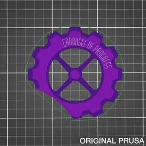 Op de afbeelding: Een paars 3D-geprint tandwiel met de tekst "Carousel of Progress" rond de omtrek.