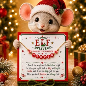 Puede incluir: Un collar dorado con cuentas de letras rojas que forman HARPER y dos cuentas de caramelo de menta, presentado en una tarjeta blanca titulada A SPECIAL ELF DELIVERY FROM SANTA'S WORKSHOP, sostenido por un rat&oacute;n de peluche con gorro de Navidad.