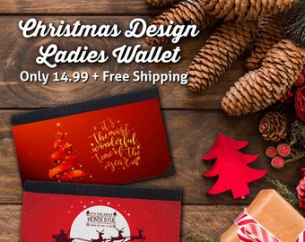 May include: Two Christmas-themed wallets with black trim. One wallet features a red Christmas tree design with the text "It's the most wonderful time of the year." The other wallet has a red background with a silhouette of Santa's sleigh and reindeer. The text "It's the most wonderful time of the year" is also present.