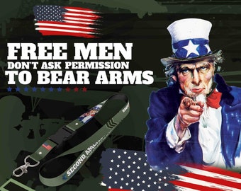 May include: Green lanyard with a white and blue American flag design and the text "Second Amendment" printed on it. The lanyard has a black clip and a silver key ring. The image also features Uncle Sam pointing with the text "Free Men Don't Ask Permission To Bear Arms" and stars.