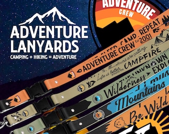 May include: Five colorful lanyards with different designs and text, including "Adventure Crew", "Campfire", "Wilderness", "Mountains", and "Be Wild".