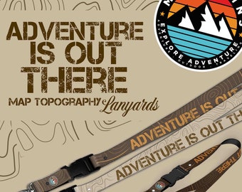 May include: Two brown and tan map topography lanyards with black clips. The lanyards have the text "Adventure is Out There" printed on them. The background is a tan color with brown lines.