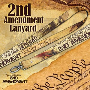 May include: A fabric lanyard featuring a sepia-toned design with historical imagery, including the text 2nd Amendment Lanyard, We the People, and Shall Not Be Infringed. The strap includes a silver-toned metal lobster clasp at the bottom end.