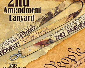 May include: A fabric lanyard featuring a sepia-toned design with historical imagery, including the text 2nd Amendment Lanyard, We the People, and Shall Not Be Infringed. The strap includes a silver-toned metal lobster clasp at the bottom end.