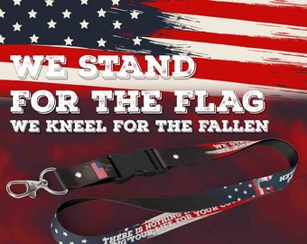 May include: A red, white, and blue lanyard with the text "WE STAND FOR THE FLAG WE KNEEL FOR THE FALLEN" and "THERE IS NOTHING LIKE RISKING YOUR LIFE FOR YOUR COUNTRY" printed on it. The lanyard has a black plastic clip and a silver metal hook.