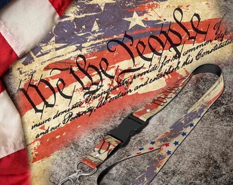 May include: A lanyard with a vintage American flag design and the text "We the People" printed on it. The lanyard has a black plastic clip and a silver metal hook.