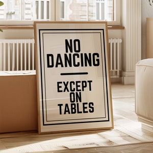 May include: A framed poster with the text "NO DANCING EXCEPT ON TABLES" in black letters on a white background.