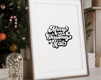 May include: A framed print with a white background and black text that reads "Merry Christmas Y'all". The print is hanging on a wall in a room decorated for Christmas.