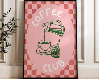 May include: A framed art print with a pink background and a green coffee-themed illustration. The words "COFFEE CLUB" are written in white. The illustration depicts a coffee cup, a creamer, and a jar of jam.