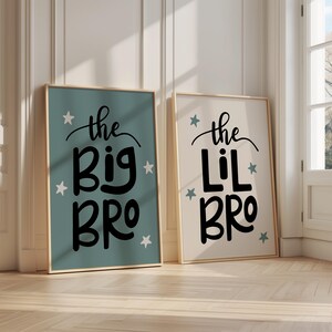 May include: Two framed prints with a light blue and white background. The text on the prints reads "the big bro" and "the lil bro" with white stars surrounding the text.