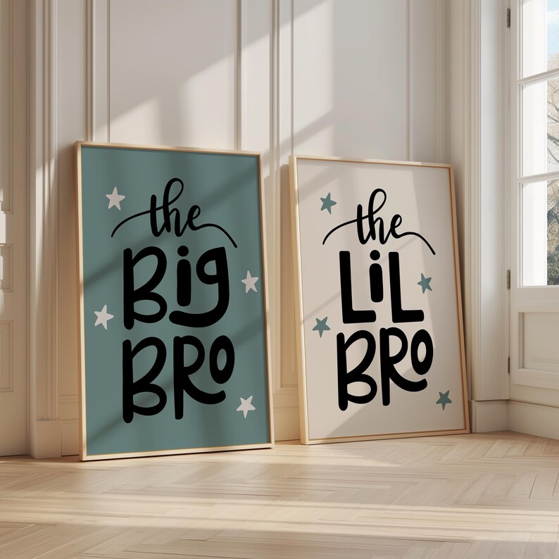 May include: Two framed prints with a light blue and white background. The text on the prints reads "the big bro" and "the lil bro" with white stars surrounding the text.