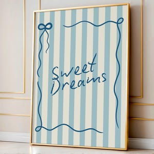 May include: A framed print with a blue and white striped background. The print features a blue cursive script that says "Sweet Dreams" within a blue decorative frame.