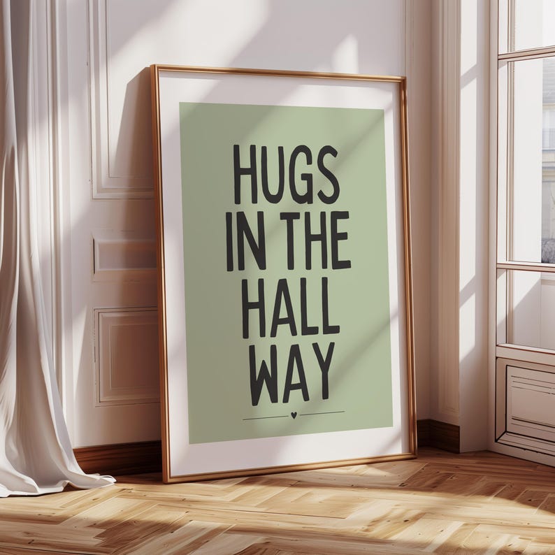 May include: A sage green poster with black text that reads "HUGS IN THE HALL WAY" with a small heart symbol at the bottom.