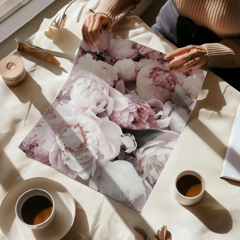 May include: A close-up of a print featuring a bouquet of soft pink peonies. The peonies are arranged in a cluster, with some petals overlapping. The print is on a white background.