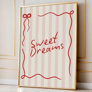 May include: A framed print with a pink and white striped background. The print features a red ribbon border with the words "Sweet Dreams" written in red cursive.