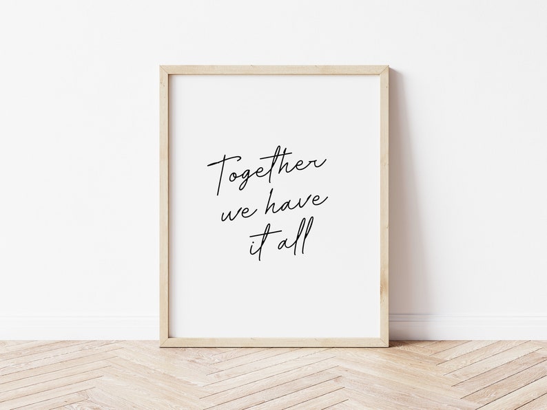 May include: A framed print with the words "Together we have it all" in black script on a white background. The frame is a light wood color, and the print is displayed against a white wall and a wooden floor.